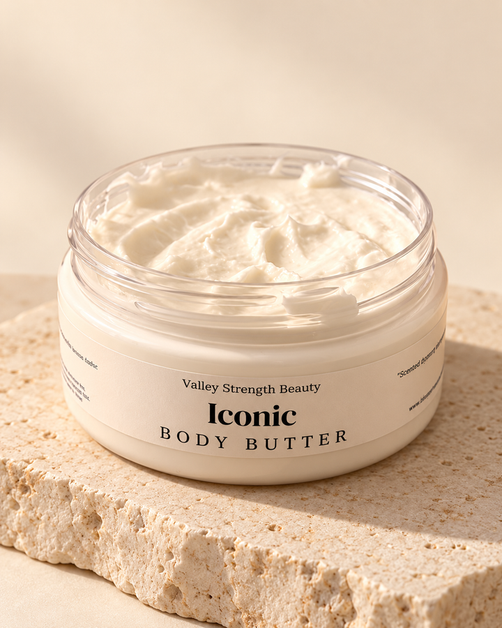 Open jar of Iconic whipped body butter on cream stone
