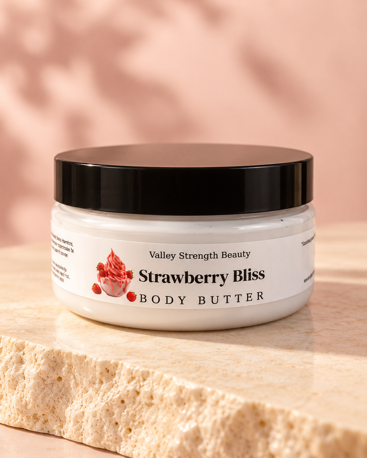 Strawberry Bliss body butter jar with black lid on cream stone