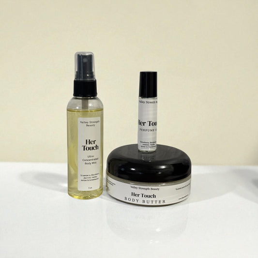 Three 'Her Touch' products including a spray bottle, a bottle, and a jar on a white surface with a beige background.